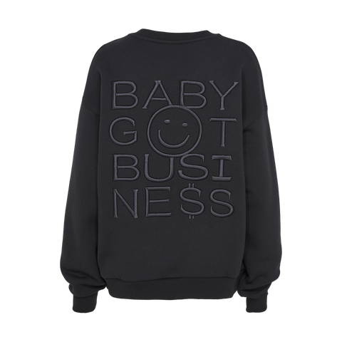 Schwarzer Sweater mit großer, geprägter Rückenstickerei "BABY GOT BUSINESS" inklusive Smiley-Gesicht in der Mitte.